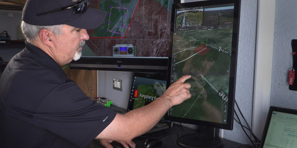 IRIS UAS program director Paige Cutland uses the IRIS UAS airspace situational awareness application to monitor the progress of a drone on a beyond line-of-sight (BVLOS) mission from a portable ground control station set up in a trailer.