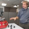 UC professor Dieter Vanderelst demonstrates his bat-inspired robot in a robotics lab. Vanderelst thinks echolocation could be a useful backup system for drone navigation.