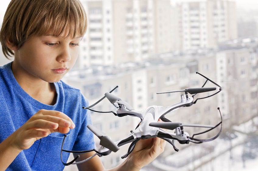 A child playing with a drone.