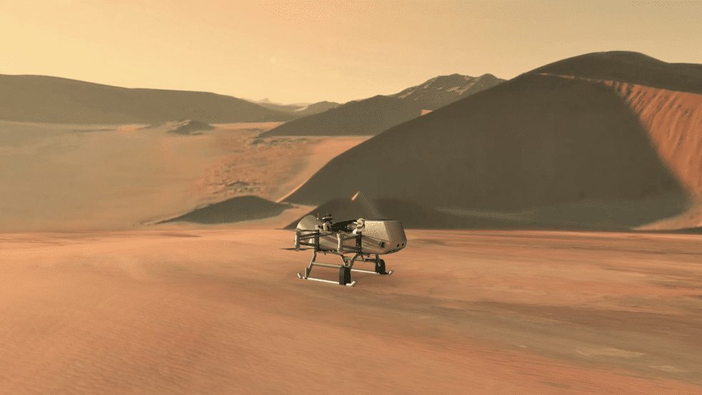 This illustration shows NASA’s Dragonfly rotorcraft-lander approaching a site on Saturn’s exotic moon, Titan. Taking advantage of Titan’s dense atmosphere and low gravity, Dragonfly will explore dozens of locations across the icy world, sampling and measuring the compositions of Titan's organic surface materials to characterize the habitability of Titan’s environment and investigate the progression of prebiotic chemistry. Credits: NASA/JHU-APL